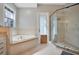 This bathroom features a large tub with granite surround and a glass-enclosed shower at 5708 Emerington Cres, Orlando, FL 32819