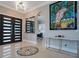 Elegant foyer with marble floors, contemporary art, stylish doors, and a view of the adjacent kitchen area at 5708 Emerington Cres, Orlando, FL 32819