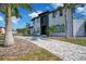 View of a modern two-story home with manicured lawn, palm trees, and a patterned driveway at 5708 Emerington Cres, Orlando, FL 32819