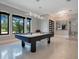Game room with a modern pool table and an abundance of natural light coming in through the large bay windows at 5708 Emerington Cres, Orlando, FL 32819