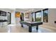 Bright game room with pool table, sports memorabilia, and large windows offering a view of the lush outdoors at 5708 Emerington Cres, Orlando, FL 32819