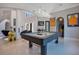 Game room with pool table, quirky art piece, and stairs leading to another level, all in a spacious, light-filled area at 5708 Emerington Cres, Orlando, FL 32819