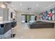 Spacious living room with a modern sofa, stylish bar seating, and large windows overlooking the pool at 5708 Emerington Cres, Orlando, FL 32819