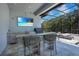 Outdoor kitchen and bar with a stainless steel grill and sink next to the pool at 5708 Emerington Cres, Orlando, FL 32819