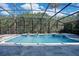 A stunning pool with a waterfall feature and fire bowls in a screened in lanai at 5708 Emerington Cres, Orlando, FL 32819