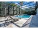 An inviting screened pool with deck chairs, a rock waterfall and fire bowls offer a relaxing outdoor space at 5708 Emerington Cres, Orlando, FL 32819