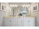 Bathroom vanity with double sinks, white cabinets, granite countertops, and stylish decor at 7206 Nottingham Reel Ct, St Cloud, FL 34773