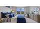 Bright bedroom with a large window offering natural light and a tufted headboard with decorative pillows at 7206 Nottingham Reel Ct, St Cloud, FL 34773