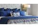 Close-up on a well-decorated bed with blue and white bedding, complete with a tufted headboard and decorative pillows at 7206 Nottingham Reel Ct, St Cloud, FL 34773
