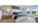 A modern bedroom with a blue and white color scheme and two large windows at 7206 Nottingham Reel Ct, St Cloud, FL 34773