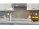 Close-up of a kitchen counter with granite countertops and decorative tile backsplash at 7206 Nottingham Reel Ct, St Cloud, FL 34773