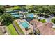Aerial view showcases a community pool, spa, playground, and well-manicured lawns with a clubhouse at 7237 Woodville Cres, Orlando, FL 32819