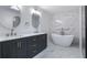 A luxurious bathroom featuring a double vanity, marble accents, and a freestanding bathtub at 7237 Woodville Cres, Orlando, FL 32819