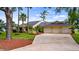 Charming single Gathering home featuring a three-car garage, mature landscaping, and a spacious driveway at 7237 Woodville Cres, Orlando, FL 32819