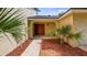 Inviting covered front entrance with double doors, mulch landscaping and nearby palm trees at 7237 Woodville Cres, Orlando, FL 32819