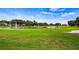 Scenic view of a lush green golf course with a serene pond and fountain, set under a beautiful blue sky at 7237 Woodville Cres, Orlando, FL 32819