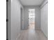 Bright hallway with light wood floors leading to a bathroom at 7237 Woodville Cres, Orlando, FL 32819