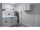 Functional laundry room with a washer, dryer, water heater, and storage at 7237 Woodville Cres, Orlando, FL 32819