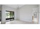 Open living room with white floors and modern lighting. Sliding glass doors overlook pond at 7237 Woodville Cres, Orlando, FL 32819