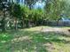 Beautiful treelined backyard with a mix of lawn and sand, enclosed by two different fence types at 734 La Costa St, Minneola, FL 34715