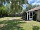 Spacious backyard featuring a screened lanai, mature trees, and a privacy fence, perfect for outdoor living at 734 La Costa St, Minneola, FL 34715