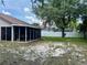 View of the screened-in lanai, large trees and expansive yard on the back of the property at 734 La Costa St, Minneola, FL 34715