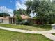 Well-maintained home with lush greenery, a tidy lawn, and mature trees at 734 La Costa St, Minneola, FL 34715
