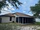 Exterior view of a home with a screened lanai showcasing the neutral color scheme and well-maintained landscaping at 734 La Costa St, Minneola, FL 34715