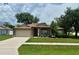 Charming single-story home with a well-maintained lawn and a two-car garage at 734 La Costa St, Minneola, FL 34715