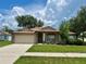 Inviting home with a manicured lawn, front garden beds, and a two-car garage at 734 La Costa St, Minneola, FL 34715