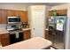 This kitchen has wood cabinets, stainless steel appliances, and a refrigerator with a water dispenser at 734 La Costa St, Minneola, FL 34715