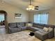 Cozy living room with a large sectional, tile flooring, and a ceiling fan at 734 La Costa St, Minneola, FL 34715