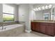 Bright bathroom featuring a soaking tub, dual vanities, and a window at 8970 Azalea Sands Ln # 2302, Davenport, FL 33896