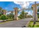 Champions Gate entrance with decorative pillars, signage, lush trees, and manicured landscaping at 8970 Azalea Sands Ln # 2302, Davenport, FL 33896