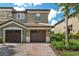 Two-story townhome featuring a tile roof, brick paver driveway, and a two-car garage at 8970 Azalea Sands Ln # 2302, Davenport, FL 33896