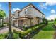 Side view of the townhome showcasing its well-maintained yard and stucco exterior at 8970 Azalea Sands Ln # 2302, Davenport, FL 33896