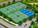 Aerial shot of tennis and pickleball courts surrounded by green spaces in a Champions Gate community at 8970 Azalea Sands Ln # 2302, Davenport, FL 33896