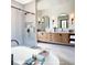 Luxurious bathroom featuring a soaking tub, glass-enclosed shower, and double vanity at 917 Lake Emerald Dr, Orlando, FL 32806