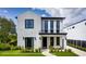 Contemporary two-story home featuring white brick, black framed windows, and a welcoming front porch at 917 Lake Emerald Dr, Orlando, FL 32806