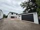 View of the modern home's rear exterior, with a detached garage featuring a black door at 917 Lake Emerald Dr, Orlando, FL 32806