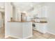 Open-concept kitchen with white cabinetry, a breakfast bar, and tile floors at 12449 Cruxbury Dr, Windermere, FL 34786
