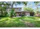 Spacious backyard with mature trees, a patio area, and lush lawn at 14202 Nell Dr, Orlando, FL 32832