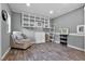 Finished bonus room with gray walls, wood floors, built-in shelves and modern chair at 14202 Nell Dr, Orlando, FL 32832