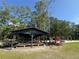 Outdoor park pavilion with picnic tables, adjacent to playground equipment and mature trees at 14202 Nell Dr, Orlando, FL 32832