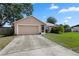 Inviting single-story home with an attached garage and a well-manicured lawn at 144 Fort Smith Blvd, Deltona, FL 32738