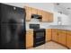 Kitchen with black appliances, laminate countertops and light wood cabinets at 144 Fort Smith Blvd, Deltona, FL 32738