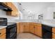 Well-lit kitchen features wood cabinets, black appliances, and an open layout at 144 Fort Smith Blvd, Deltona, FL 32738