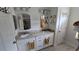 Bathroom with dual vanities with granite countertops, decorative mirrors, and white cabinetry at 148 Peregrine Ct, Winter Springs, FL 32708