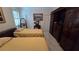 Cozy bedroom featuring two twin beds, neutral decor, and a storage cabinet with a built-in television at 148 Peregrine Ct, Winter Springs, FL 32708