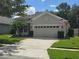Charming single-story home with a manicured lawn, complemented by a beige exterior and a two-car garage at 148 Peregrine Ct, Winter Springs, FL 32708